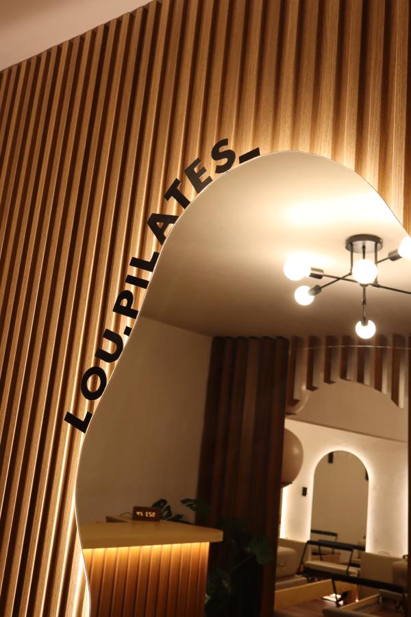 Arco de la sala con el nombre lóu pilates y lámpara cálida